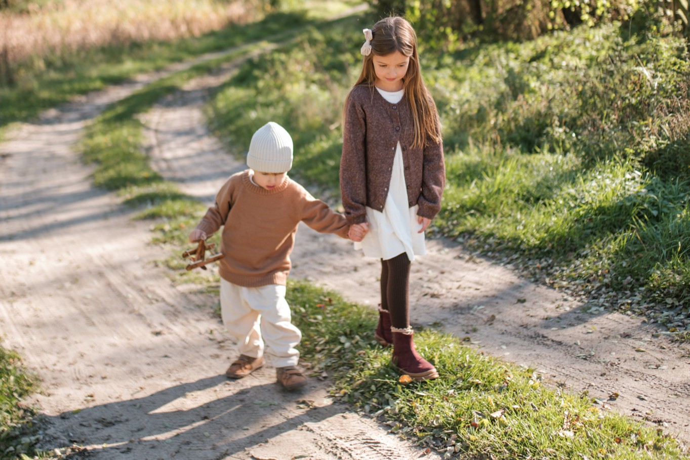 Chłopiec i dziewczynka spacerują w jesiennej scenerii w skórzanych bucikach marki Emel.