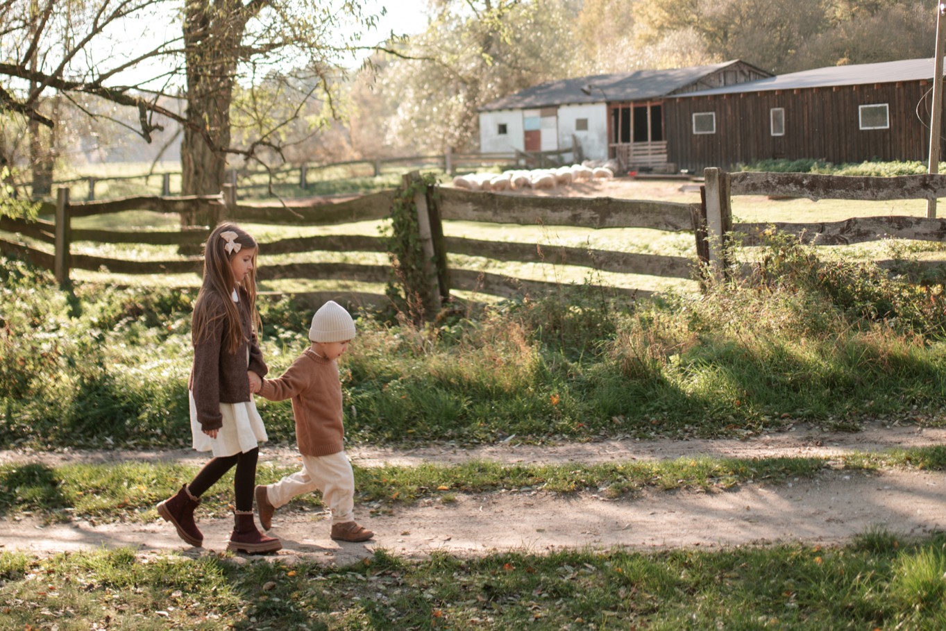 Skórzane buciki dziecięce Emel – dziewczynka i chłopiec spacerują, wygodne i ręcznie wykonane obuwie wspierające prawidłowy rozwój stóp dziecka.
